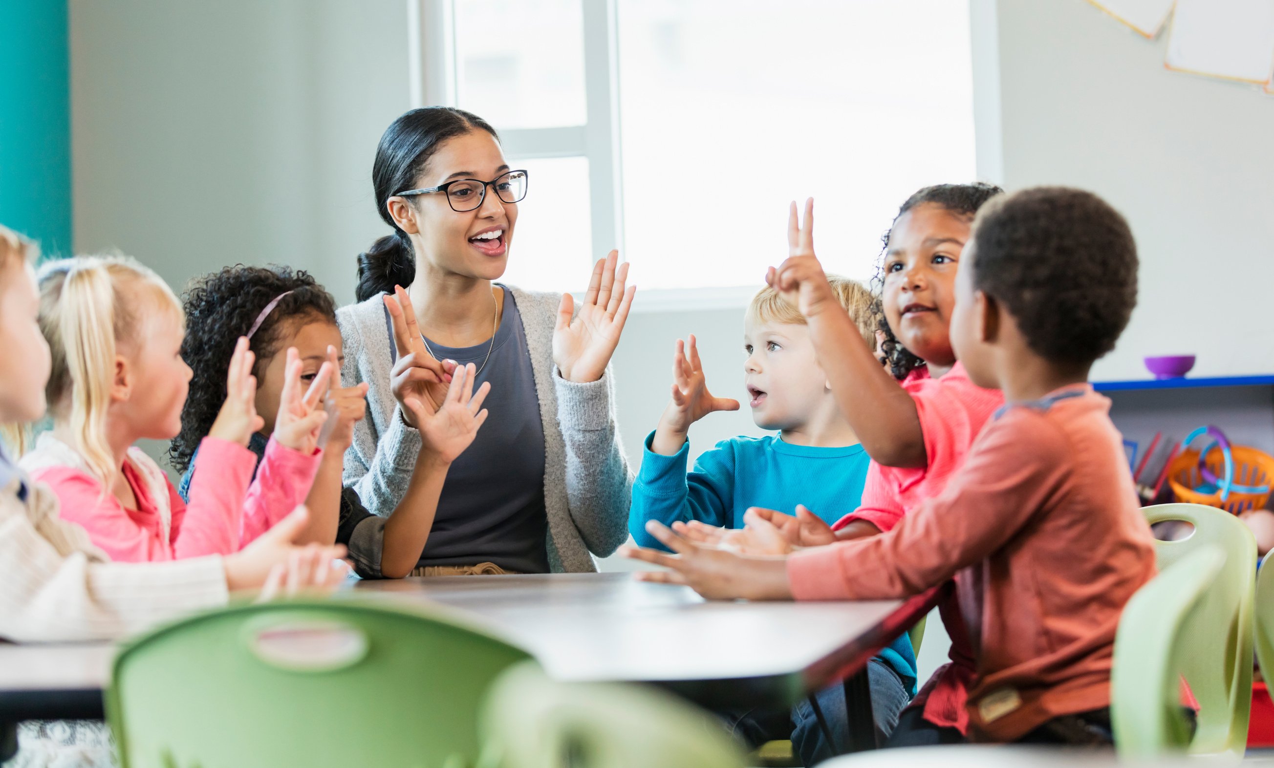 Multi-ethnic preschool teacher and students in classroom